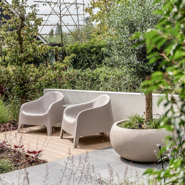 Outdoor installation of the Ember-Low planter from the Oterra family in the Vivo Collection. Shown in Oat finish with greenery.