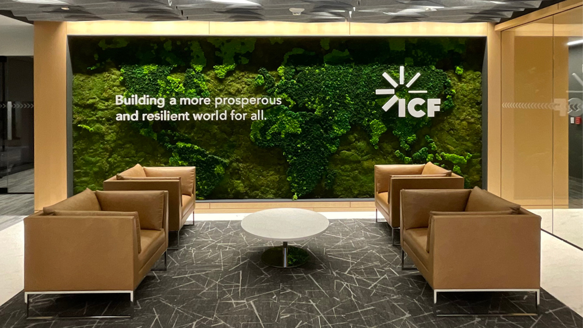 Custom preserved moss wall installation with ICF International logo and seating area in Reston corporate office.
