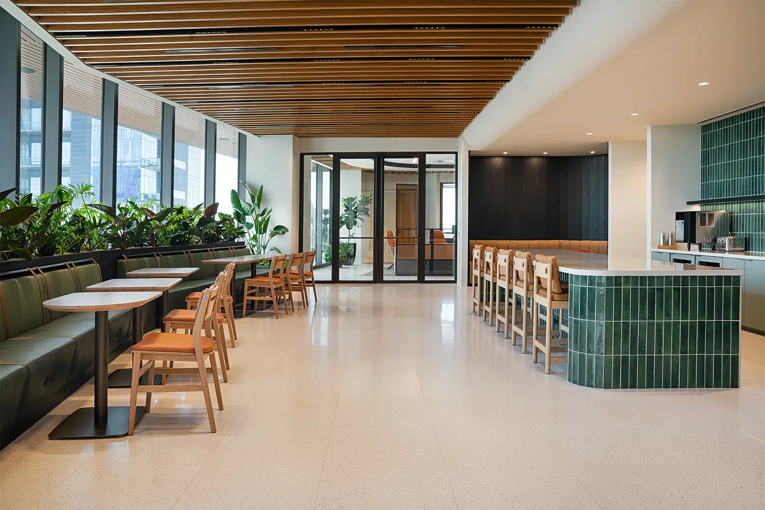 Integrated interior planters with lush greenery in the work cafe of an Austin law firm.